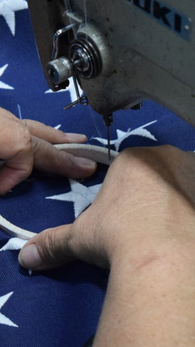 Elizabeth Ross Flags factory worker hand embroidering one of the 50 stars on an American flag.